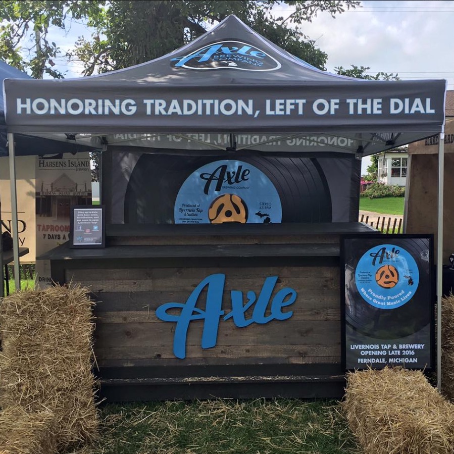 Axel Brewing Co. uses a custom back wall to bring their custom tent to life.
