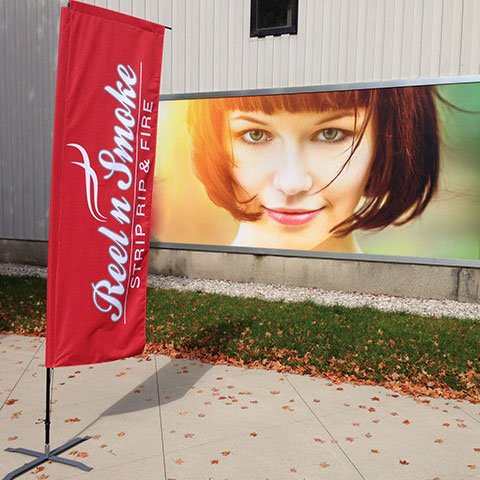 A red printed marketing flag on cross base used for event marketing.